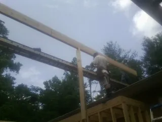 Carpenter setting a ridge beam over a new addition frame — Ice Dam Removal by Roofing Brothers in Plattsburg